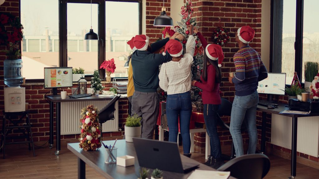 Diverse group of colleagues decorating christmas tree